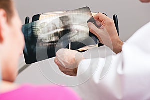 Dentist explaining x-ray to patient photo