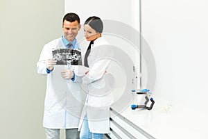 Dentist and female assistant are discussing dental X Ray image