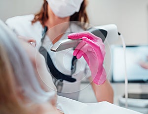 Dentist female doctor in uniform using intraoral 3D dental scanner Machine for clear aligners production. Dental clinic patient