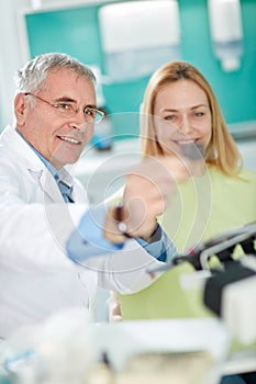 Dentist with female patient look at dental snapshot