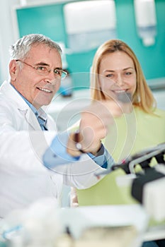 Dentist with female patient look at dental snapshot photo