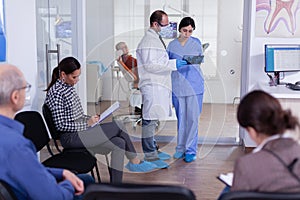 Dentist finishing teeth treatment for old man