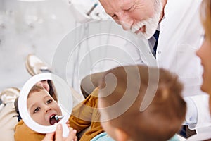 Dentist fixing tooth to a little boy