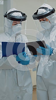 Dentist giving tablet to dental nurse before consultation