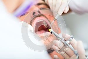 Dentist giving treatment - anesthetization syringe