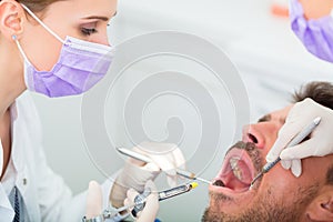 Dentist giving treatment - anesthetization syringe