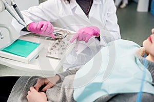 Dentist with gloved hands is treating patient with dental tools in dental office. Dentistry