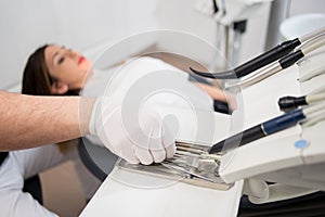 Dentist with gloved hands is treating patient with dental tools in dental office. Dentistry