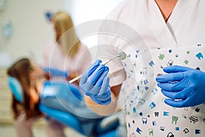 Dentist in the gloves holds tool mirror. Stomatological instrument in the dentist& x27;s clinic