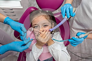 dentist is going to perform a dental examination of a frightened child in a dental clinic.