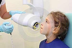 Dentist hands make jaw x-ray image for girl