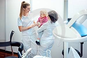 Dentist and her assistant with child in the office