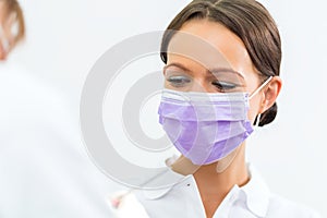 Dentist in her practice giving dental treatment