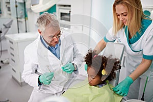 Dentist and his assistant comfort little girl