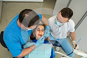 the dentist and his assistant examine the oral cavity and treat the client
