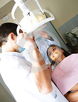 Dentist and his assistant examine a patient