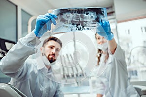 Dentist and his assistant are talking about patient`s file. Selective focus