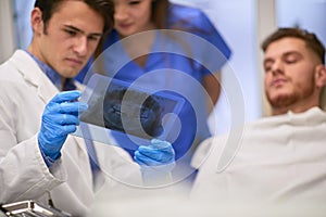 Dentist and his nurse observing an x-ray