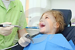 Dentist hold grinding drill, girl opens her mouth