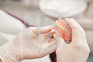 Dentist holding dentures in her hands