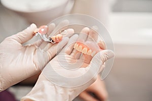 Dentist holding dentures in office room