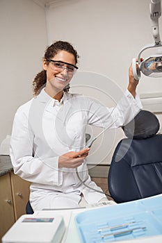 Dentist holding drill smiling at camera