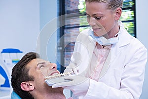 Dentist holding equipment while examining patient at medical clinic