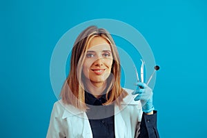 Dentist Holding Medical Instruments on a Blue Background