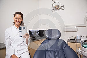 Dentist holding xrays smiling at camera