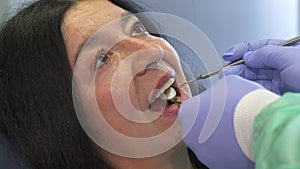 Dentist holds dental instruments in client`s mouth
