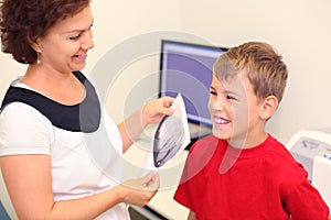 Dentist holds jaw x-ray image for boy photo