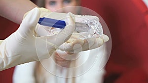 Dentist holds syringe with gel for cleaning teeth