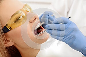 Dentist identifying cavities in mouth of patient