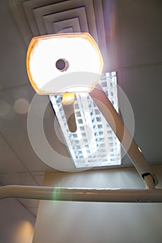 Dentist lighting equipment powered on from the angle of the patient's seat.