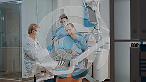 Dentist looking at dental x ray and consulting patient with toothache