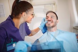 Dentist looking patientâ€™s teeth
