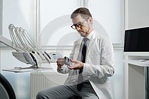 Dentist looking at photopolymer jaw printed on a 3d printer.