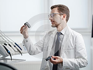 Dentist looking at photopolymer jaw printed on a 3d printer.