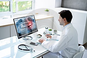 Dentist Looking At Teeth X-ray On Computer