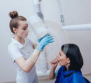 Dentist make x-ray image for young woman in dental clinic.