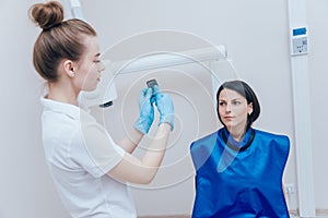 Dentist make x-ray image for young woman in dental clinic.