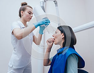 Dentist make x-ray image for young woman in dental clinic.