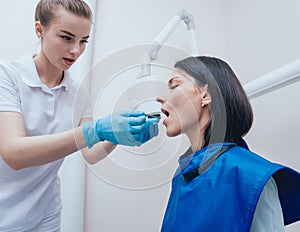 Dentist make x-ray image for young woman in dental clinic.