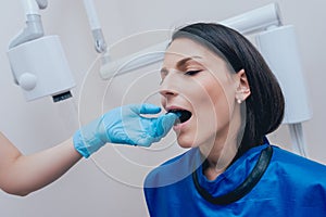 Dentist make x-ray image for young woman in dental clinic.