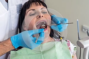 The dentist makes patients prophylactic examination