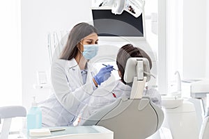 Dentist making check up for patient in dental clinic