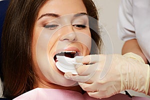 Dentist making teeth whitening procedure