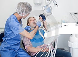 Dentist male in uniform is examinating of female in dental clinic