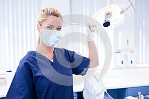 Dentist in mask holding light