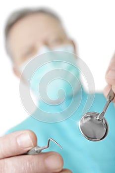 Dentist with a mirror and hook with selective focus